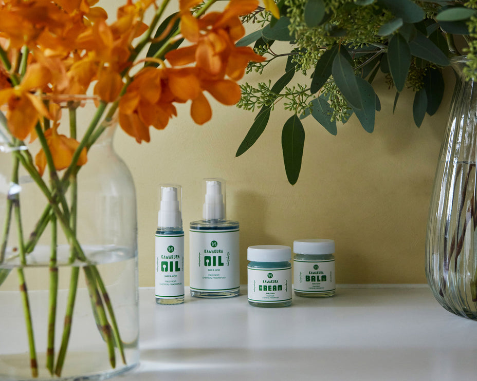 オレンジの花と緑の植物に囲まれたH PRODUCT製品、ナチュラルな雰囲気の陳列