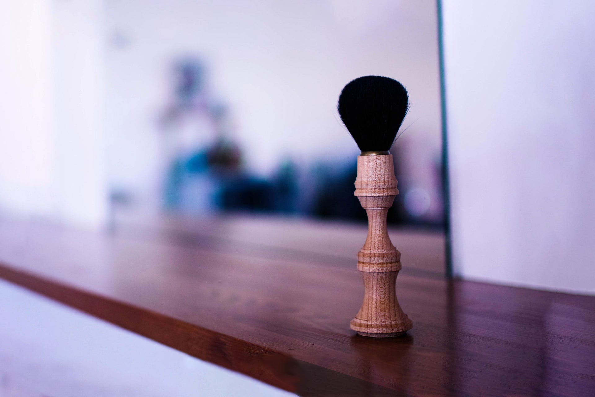 木製の柄を持つ黒いブラシ、美容室の鏡の前に置かれた道具